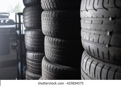 Sunlight In The Tire Storage. Stack Of Old Tires In A Car Shop Garage. Tire Installation Service.