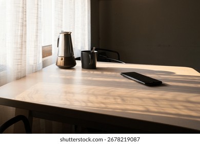 Sunlit coffee table scene featuring a moka pot, a mug, and a smartphone, creating a cozy and inviting atmosphere