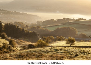 Sunlit Countryside Landscape with Rolling Hills and Misty Morning in the Peak District of England. - Powered by Shutterstock