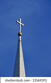 Sunlit Cross Atop A Church Spire