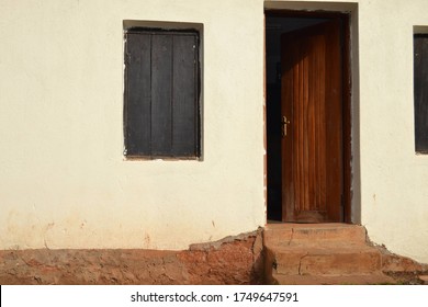 Sunlit front door and shuttered windows of a house in Uganda. 