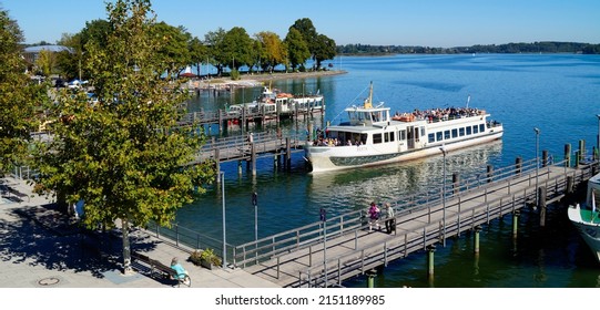 sunlit harbour of Prien on lake Chiemsee, Bavaria (Germany) with the Alps in the background on 27th September of 2018	                               