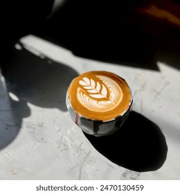 Sunlit Latte Art Coffee Cup on White Surface - Powered by Shutterstock