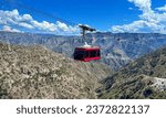 A sunlit panoramic view of Copper Canyon, with a cable car full of tourists capturing moments against the sprawling natural vista, under a nearly clear sky, with no identifiable traces of individuals