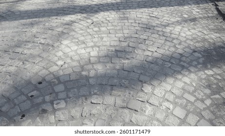 Sunlit stone cobblestone pavement patterns