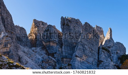 Sunny autumn alpine Dolomites rocky  mountain scene, Sudtirol, Italy. Cinque Torri (Five pillars or towers) rock famous formation. Climbers unrecognizable.