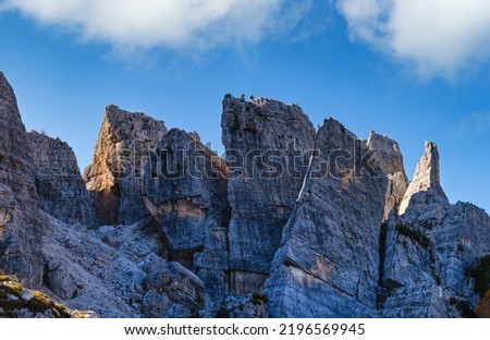 Sunny autumn alpine Dolomites rocky  mountain scene, Sudtirol, Italy. Cinque Torri (Five pillars or towers) rock famous formation.  Climbers unrecognizable.