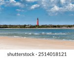 Sunny beach and Lighthouse Ponce de Leon Inlet from New Smyrna beach, Florida.