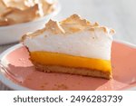 Sunny and Bright Orange Lemon Citrus Meringue Pie on a coral plate with pie in background