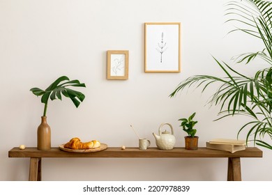 Sunny and cozy interior of living room with wooden bench, furniture, mock up poster frame, leaf in vase, tea pot, decoration and personal accessories. Stylish home decor. Template. - Powered by Shutterstock