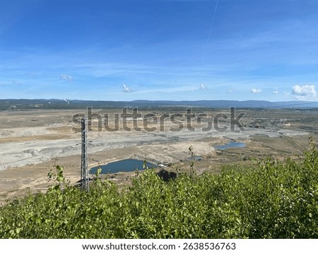 Sunny day at Medard Lake near Sokolov, Czech Republic, featuring clear water, forest views, and a modern lookout tower surrounded by nature and bike trails.