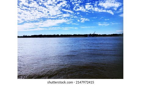 A Sunny Day At The Mississippi River Right Outside Baton Rouge! Very Amazing Sky And Water With A Few Barges In Sight.