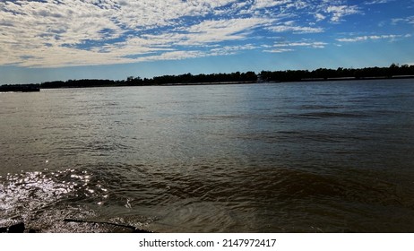 A Sunny Day At The Mississippi River Right Outside Baton Rouge! Very Amazing Sky And Water With A Few Barges In Sight.