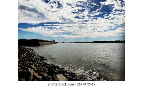 A Sunny Day At The Mississippi River Right Outside Baton Rouge! Very Amazing Sky And Water With A Few Barges In Sight.