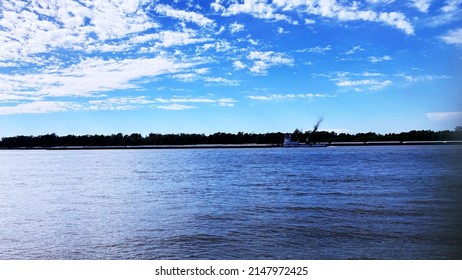 A Sunny Day At The Mississippi River Right Outside Baton Rouge! Very Amazing Sky And Water With A Few Barges In Sight.