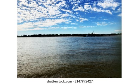 A Sunny Day At The Mississippi River Right Outside Baton Rouge! Very Amazing Sky And Water With A Few Barges In Sight.