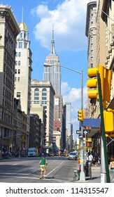 A Sunny Day In New York With A Street And The Empire State Building In The Background