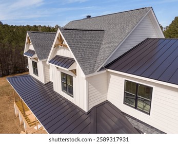 Sunny Daytime Drone Images of a Custom Home in the Final Stages of Construction. It Features a Roof With Architectural Asphalt Shingles and Standing Seam Accents: Architecture, Industry, Occupations