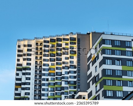 Sunny evening light on the facade of a multi-storey building. Facade wall of a new modern residential building. Construction concept, residential quarter.