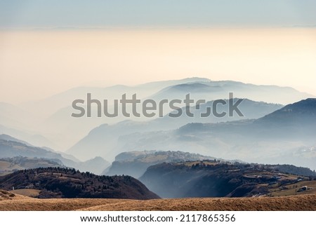Sunny foothills and hills and Padana plain or Po valley with fog, seen from Lessinia plateau (Altopiano della Lessinia), on horizon the mountain range of the Apennines. Erbezzo, Verona, Veneto, Italy.
