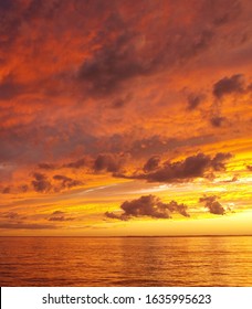 A sunny inspirational orange coloured stratocumulus cloudy coastal sunset seascape over the ocean with water reflections. Queensland, Australia. - Shutterstock ID 1635995623