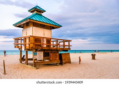 Sunny Isles Beach, USA - May 7, 2018: Lifeguard building along ocean coast in Miami, Florida evening sunset with people walking on sand