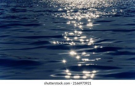 Sunny path on the water, glare. River, lake, sea, ocean, blue water. Calm mood, romance, magic. Blurred background