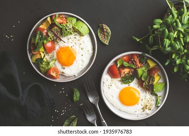 Sunny side up egg breakfast with avocado salad on plate, top view. Healthy breakfast food