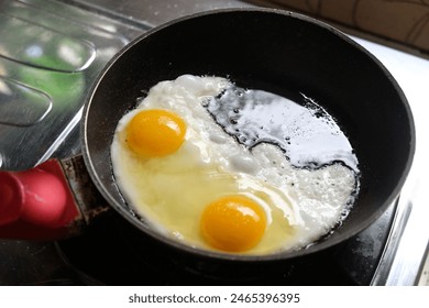 sunny side up eggs on a black frying pan on a gas stove. telur ceplok or mata sapi. - Powered by Shutterstock