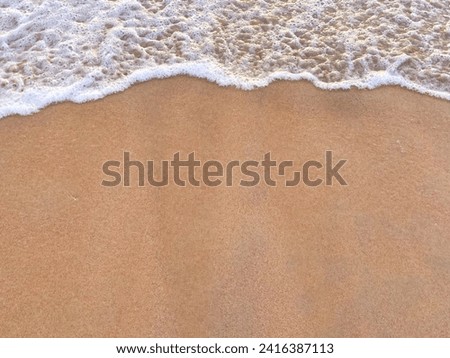 sunny Small, Soft wave on sand beach, text copy space for banners, cards. Close up top view of sea blue waves break on sand. photo was shot in evening at sunset