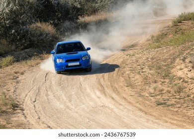 Sunny summer day. Dusty rally track. A rally car makes a lot of dust in a turn 18 - Powered by Shutterstock