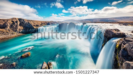 Sunny summer scene of Skjalfandafljot river, Iceland, Europe. Panoramic morning view of Godafoss, spectacular waterfall plunging over a curved, 12m-high precipice, with paths to various viewpoints. 