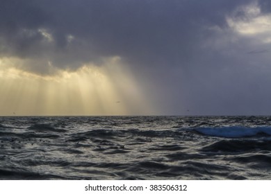 Sunrays above the ocean with dramatic clouds