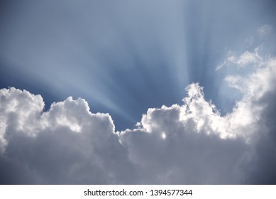 Sunrays: atmospheric coditions highlight the rays of the sun bursting from behind Cumulus cloud