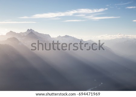 Sunrays shining over the valley surrounded by the beautiful mountain peaks near Squamish, North of Vancouver, British Columbia, Canada.