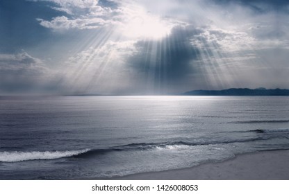 Sunrays shining through clouds on beach