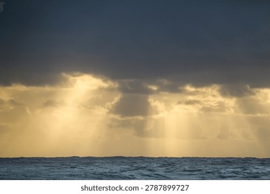 Sunrays shining through dark clouds over the ocean near Margaret River in Western Australia