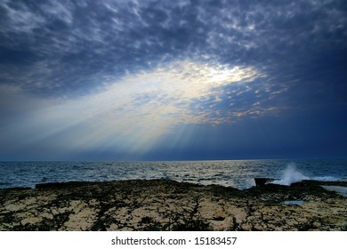Sun-rays shooting trough a cloud on a beach.
