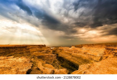 The sunrays through the clouds over the canyon. Canyon under rainy clouds. Clouds over canyon. Canyon panorama