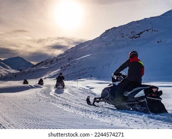 Sunrise in the alps  on a snowy plain with a snowmobile