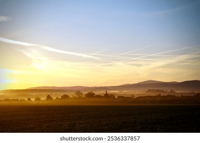 Sunrise, autumn, farmland, countryside, foggy, golden sunlight, early morning, trees, village, colourful sky - Powered by Shutterstock