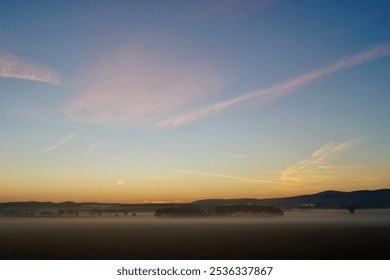 Sunrise, autumn, farmland, countryside, foggy, golden sunlight, early morning, trees, village, colourful sky - Powered by Shutterstock