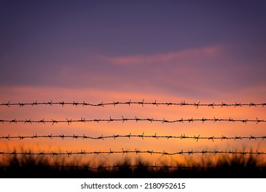 Sunrise Behind A Wooden Barbed Wire Fence Over Natural Prairie Grasslands.