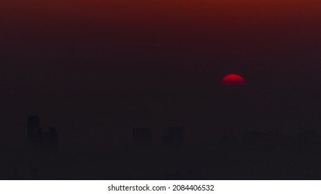 Sunrise Close Up View Over Dubai Skyline In The Morning, Aerial Top View From Dubai Marina Timelapse. Big Sun On Orange Sky Rise Over Fog Around Skyscrapers. United Arab Emirates