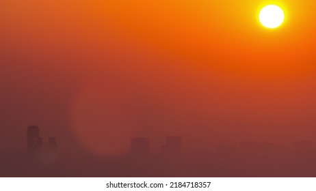 Sunrise Close Up View Over Dubai Skyline In The Morning, Aerial Top View From Dubai Marina Timelapse. Big Sun On Orange Sky Rise Over Fog Around Skyscrapers. United Arab Emirates