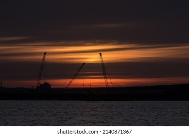 SUNRISE IN COAST - Cranes At The Construction Site In The Sea Port 
