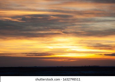 sunrise with dramatic clouds over prairie farming fields
