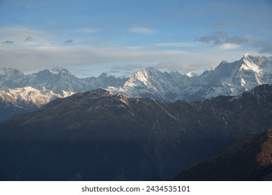 Sunrise in Himalayan mountains with snow. The sky is blue and orange with clouds. - Powered by Shutterstock