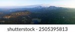 Sunrise illuminates Todd Lake and Three Sisters mountains, Oregon, during summer. These mountains and their surrounding forests, near Bend, provide exceptional hiking, biking, climbing, and camping.