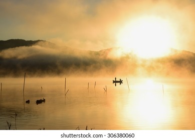 Sunrise at the lake Kawaguchiko,People fishing on a boat,silhouette. beautiful landscape.  